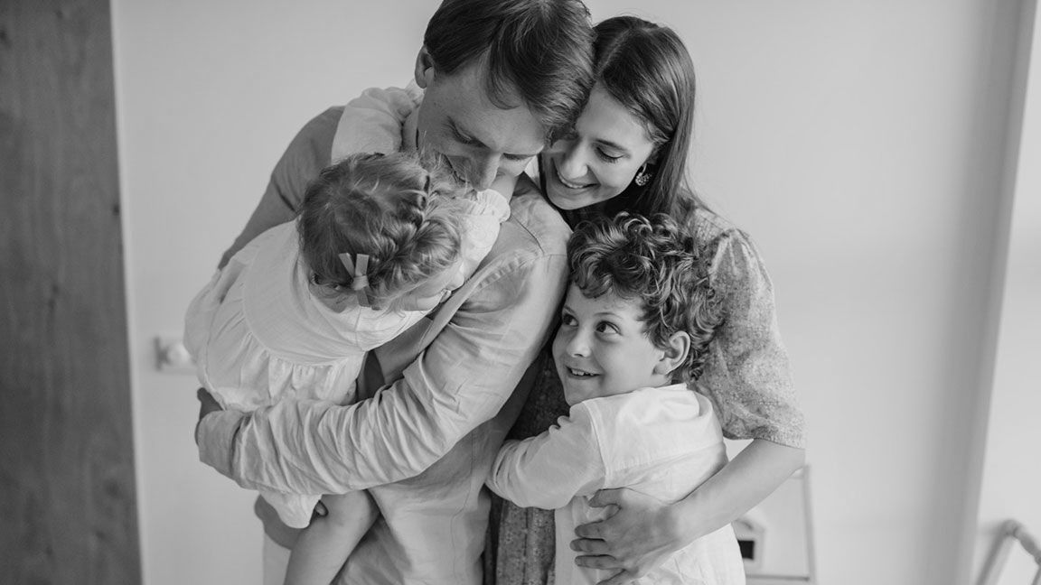 Family of four hugging each other - Learn more about the Insurance Products and Services we offer